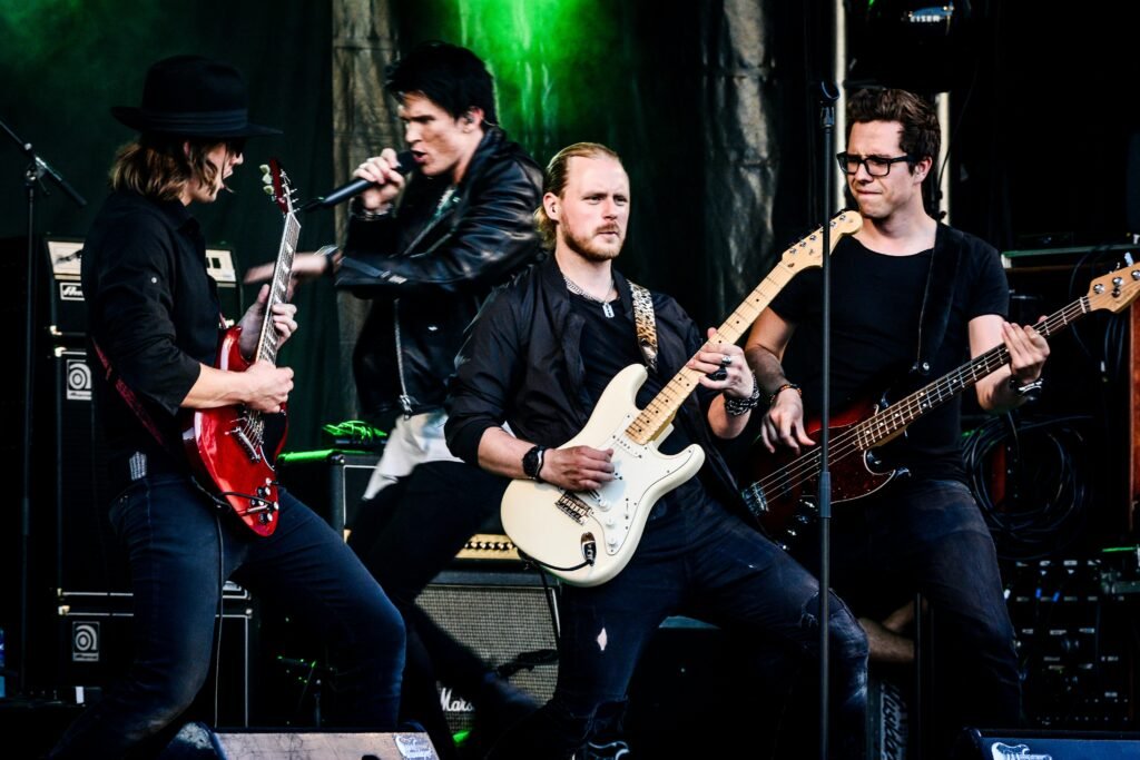 Rock band performing live with guitars and microphone on stage. Energetic and dynamic concert vibe.
