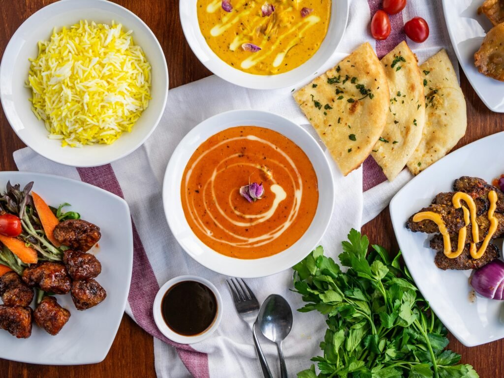 An array of authentic Indian dishes featuring curries, naan, and biryani, showcasing vibrant flavors and spices.