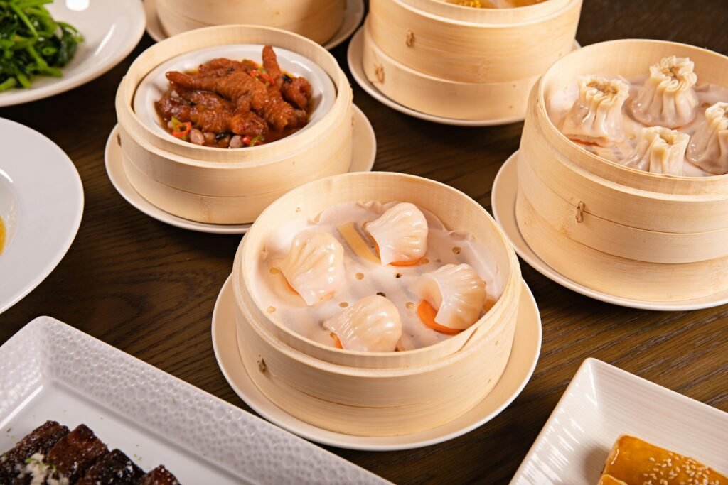 Delicious assortment of dim sum served in bamboo steamers on a wooden table.