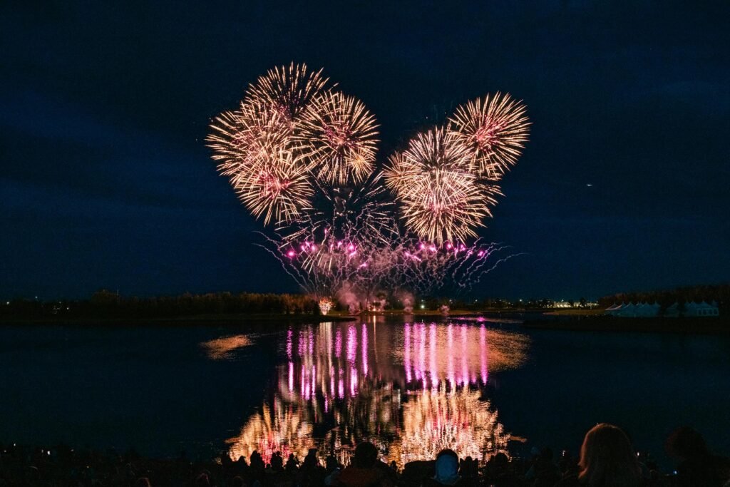 Stunning fireworks display reflecting on water in Calgary during GlobalFest festival.