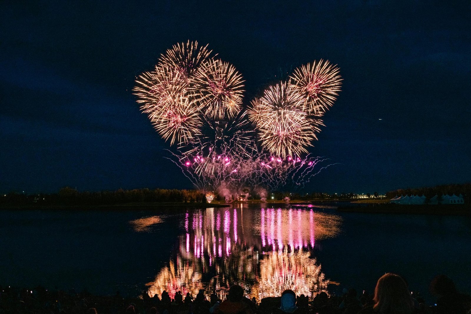 Stunning fireworks display reflecting on water in Calgary during GlobalFest festival.