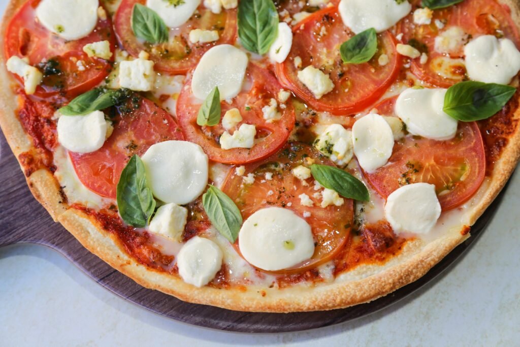 Delicious homemade Margherita pizza topped with fresh basil and mozzarella cheese.
