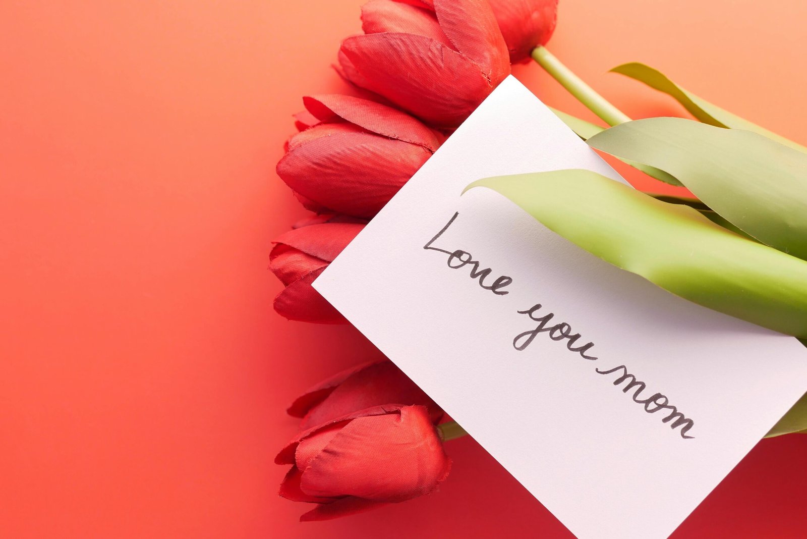 Red tulips and a 'Love you mom' card perfect for Mother's Day greetings.