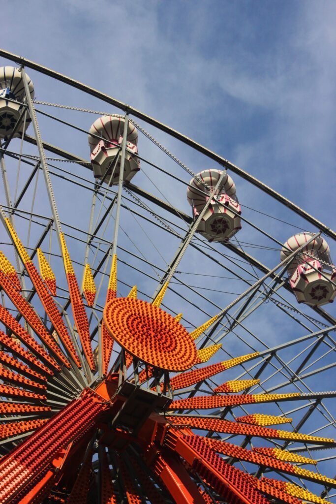 Vibrant Ferris wheel with colorful lights set against a clear blue sky.