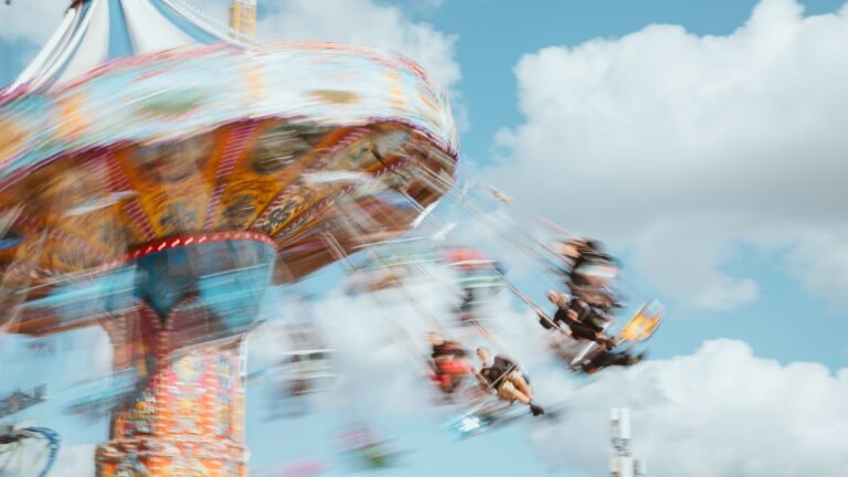 Blurred motion of a vibrant carousel ride against a blue sky in Munich, Germany.