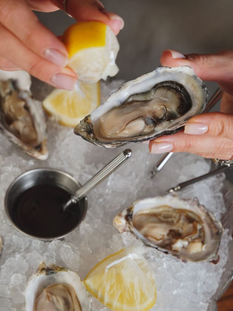 Close-up of fresh oysters on ice with lemon, ready to be served.