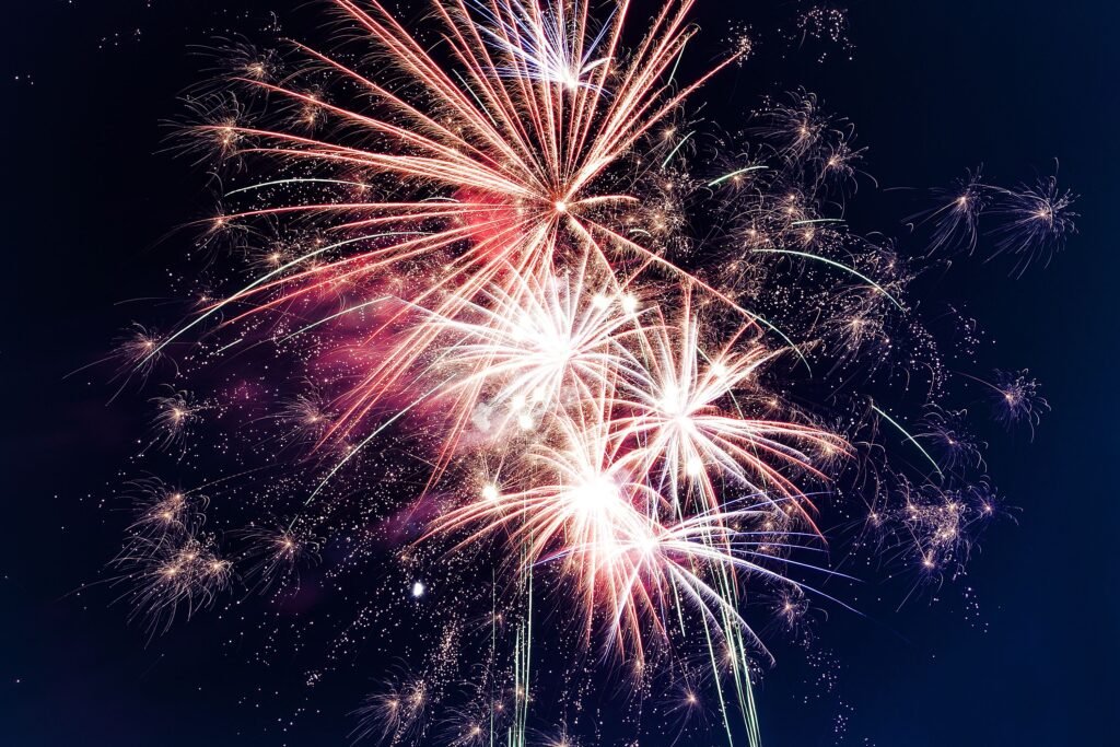 Colorful fireworks exploding in the night sky creating a festive atmosphere.